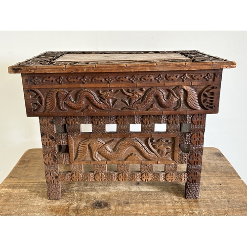 252 - An antique Chinese portable wooden fold-up scribe or reading table decorated with dragons to the top... 