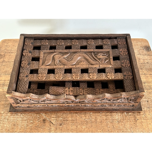 252 - An antique Chinese portable wooden fold-up scribe or reading table decorated with dragons to the top... 