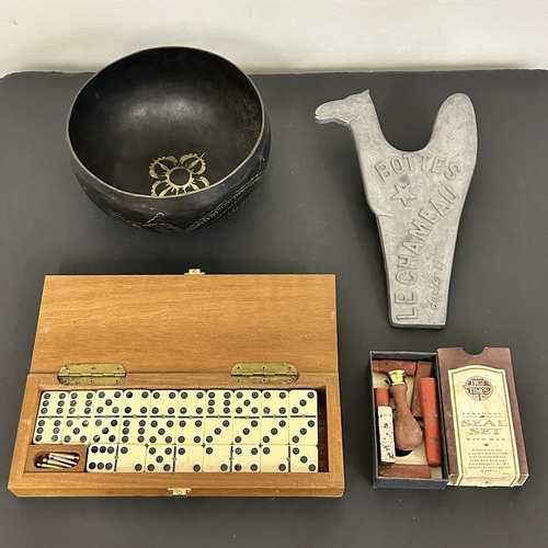 322 - A mixed lot of items to include a singing bowl, an aluminium boot jack, boxed dominos with crib boar... 