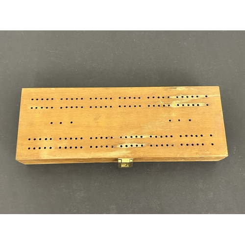 322 - A mixed lot of items to include a singing bowl, an aluminium boot jack, boxed dominos with crib boar... 