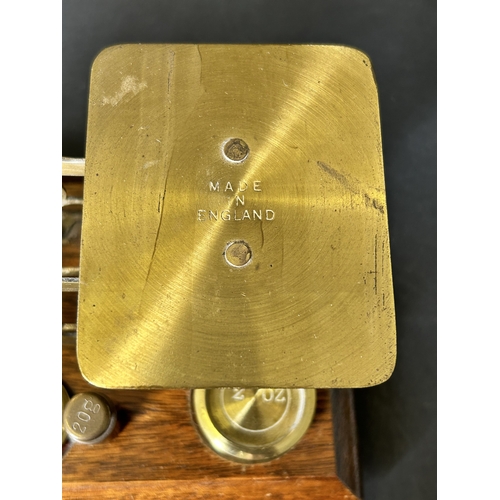 84 - A set of vintage brass postal scales on an oak base with weights