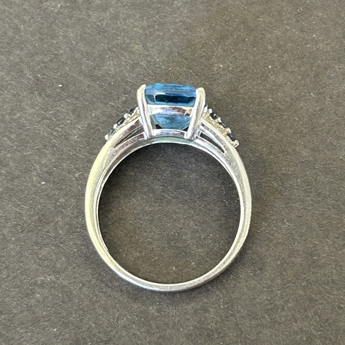 126 - A 9ct white gold ring with blue stone and mini diamond chips in shoulders, approx. size N, weight ap... 