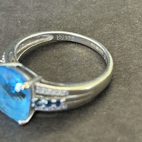 126 - A 9ct white gold ring with blue stone and mini diamond chips in shoulders, approx. size N, weight ap... 