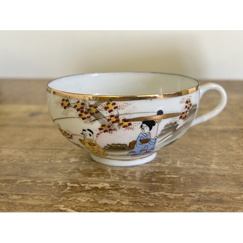 23 - A vintage Japanese porcelain tea set with hand painted decoration in a 12 setting including a teapot... 