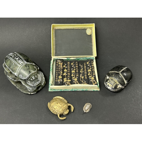 Two carved stone scarabs together with two metal examples and a cased ...