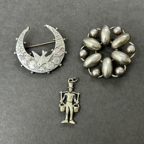 303 - A hallmarked silver crescent shape brooch with bird together with an 835 grade mini figure and an 83... 