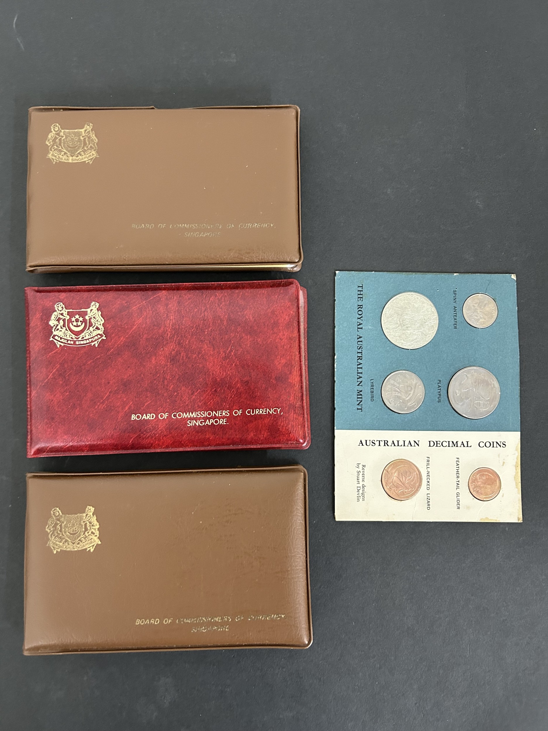 Three Singapore coin collection wallets together with an Australian ...