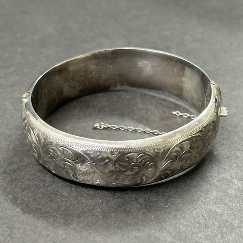 362 - A Chester hallmarked silver bangle, weight approx. 25g (safety chain as found, a few shallow dents)