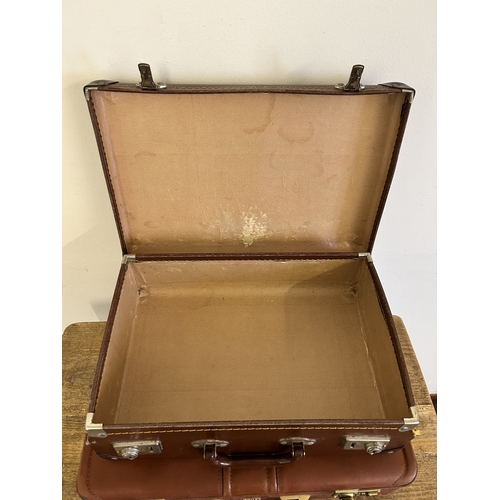 37 - Two vintage leather style small suitcases plus a leather briefcase (with age related wear)