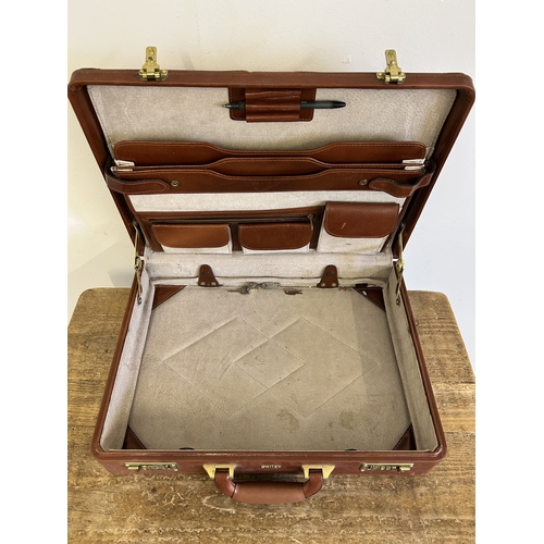 37 - Two vintage leather style small suitcases plus a leather briefcase (with age related wear)