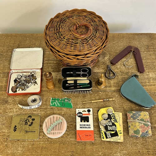 92 - A vintage wicker basket with sewing related contents together with a treen needle holder and former ... 