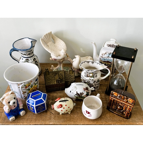 267 - Novelty money boxes, jugs, a teapot, ornamental doves together with a one hour sand timer and a COPY... 