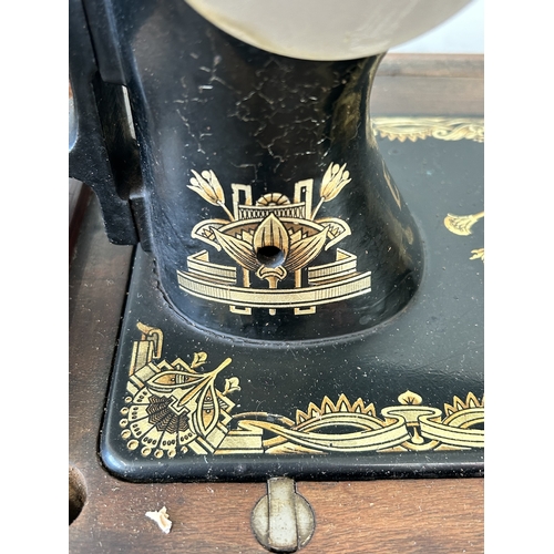 478 - An antique wood cased Frister & Rossmann manual sewing machine with gilded Egyptian decoration (box ... 