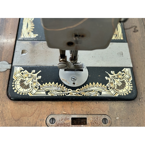478 - An antique wood cased Frister & Rossmann manual sewing machine with gilded Egyptian decoration (box ... 