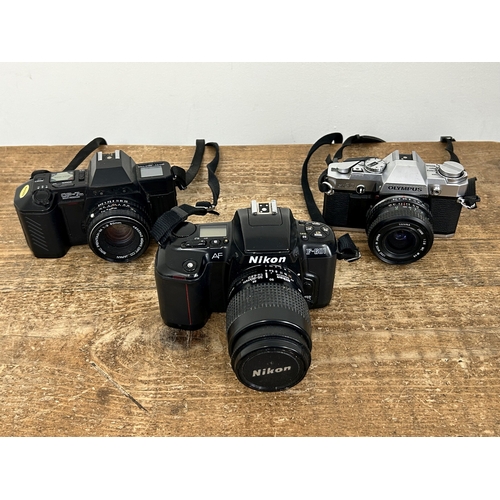 231 - Three vintage 35mm SLR cameras to include a Nikon F-601, a Chinon CP7 (missing badge) and Olympus OM... 