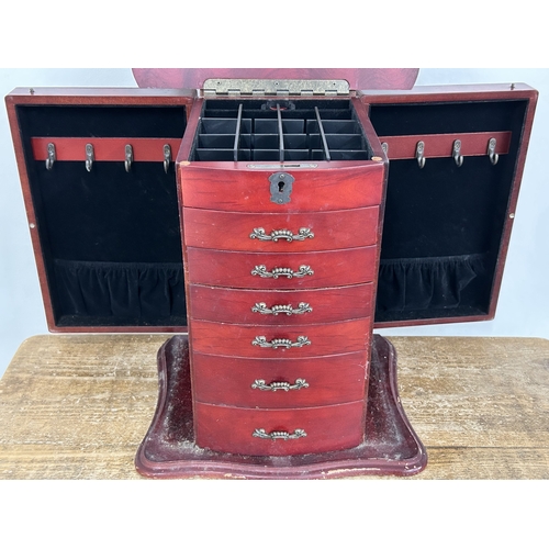 64 - A vintage Oriental style multi drawer jewellery chest with side doors, lift lid and secret drawer lo... 