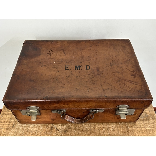 66 - A vintage leather suitcase with working catches and monogrammed top together with a leather satchel,... 