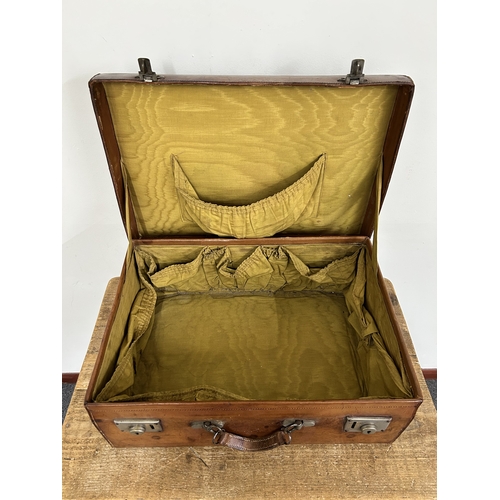 66 - A vintage leather suitcase with working catches and monogrammed top together with a leather satchel,... 