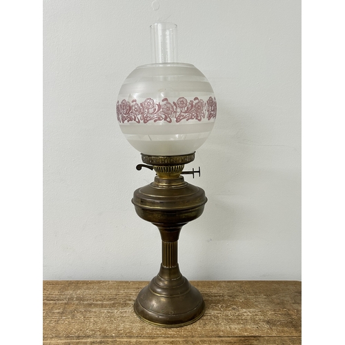 74 - A vintage brass base oil lamp with glass shade, approx. 22