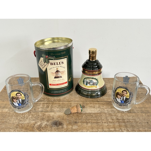 77 - A cannistered 1990 Bells Whisky decanter (empty) plus two Charles and Diana glass tankards