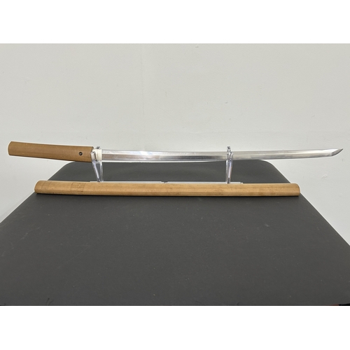 200 - An antique Japanese Katana in a natural wood scabbard, no marks to tang, polished blade with hamon m... 