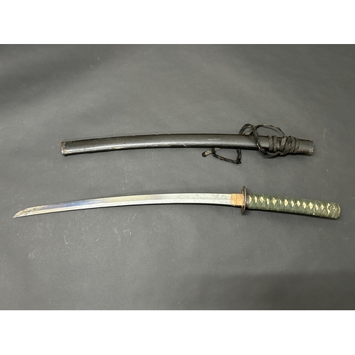 203 - An antique Wakizashi Japanese sword in scabbard, polished with traces of hamon marks, decorated Tsub... 