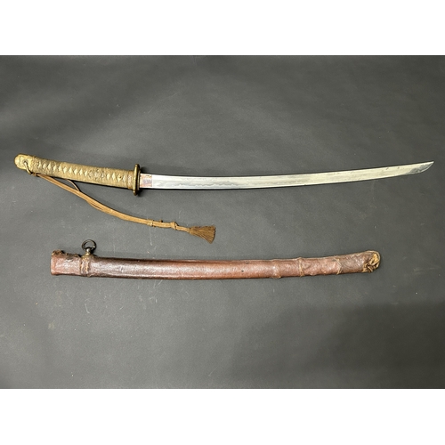 215 - A Shin-Gunto Japanese sword in a leather covered metal military scabbard, old blade with hamon marks... 