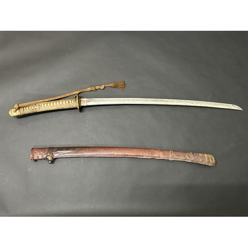 215 - A Shin-Gunto Japanese sword in a leather covered metal military scabbard, old blade with hamon marks... 