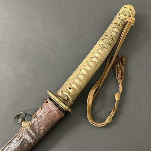 215 - A Shin-Gunto Japanese sword in a leather covered metal military scabbard, old blade with hamon marks... 
