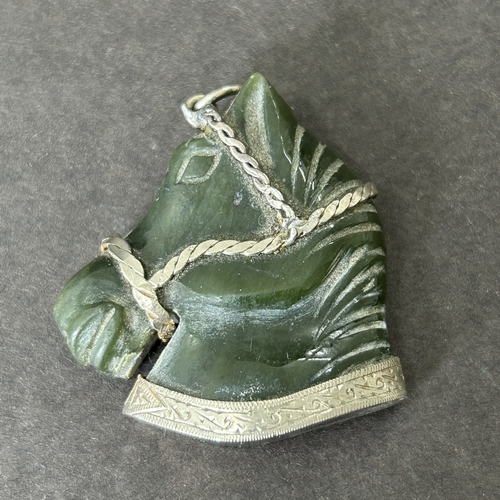 11 - An antique white metal frame containing a carved green stone horse head, approx. 1 1/2