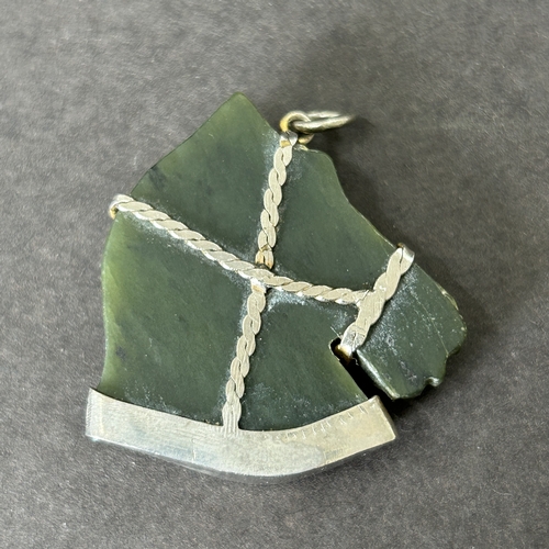 11 - An antique white metal frame containing a carved green stone horse head, approx. 1 1/2