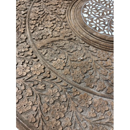 233 - Heavily carved Indian coffee table with foldable legs and removable inlaid top