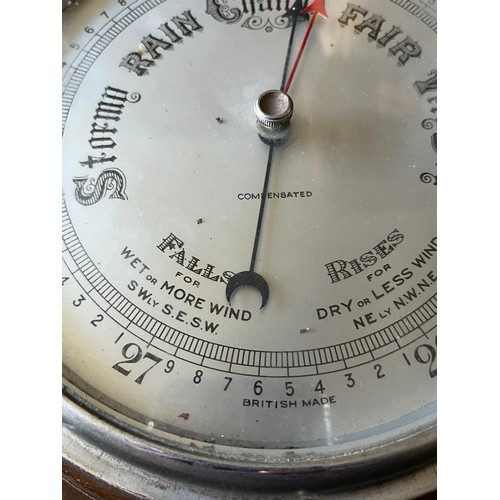 782 - Old Wood cased wall hanging Barometer with stamp to reverse Made in England to front. Diameter 9