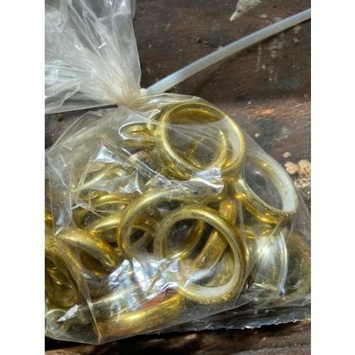 826 - Bag of brass coloured plastic curtain rings