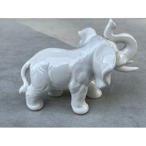 1051 - Small blanche de chine white chinaware elephant wwith trunk raised.