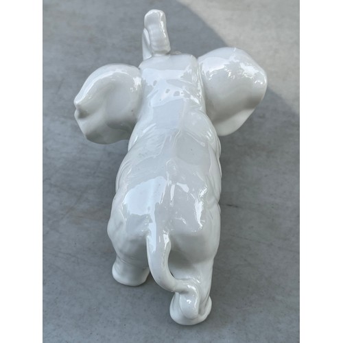 1051 - Small blanche de chine white chinaware elephant wwith trunk raised.