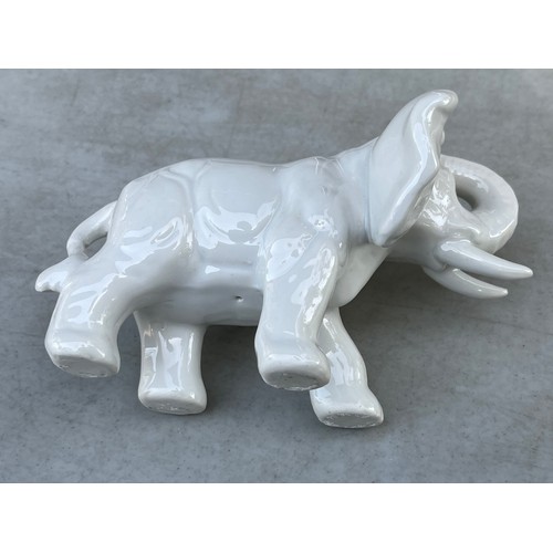 1051 - Small blanche de chine white chinaware elephant wwith trunk raised.