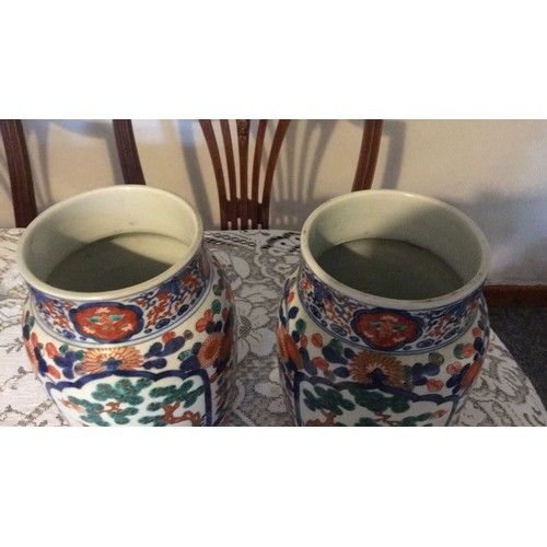 10 - The pair of Oriental in Imari pottery decorative vases, signed under