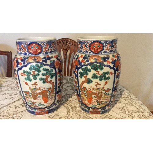 10 - The pair of Oriental in Imari pottery decorative vases, signed under