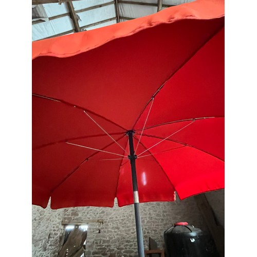 198 - Orange garden parasol. Wind up with heavy cast iron stand.