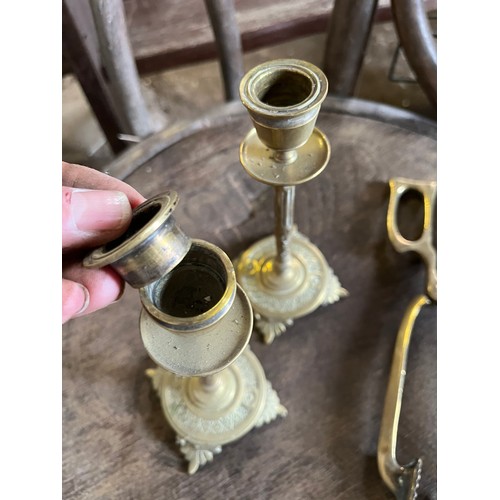 542 - Two brass candlesticks and a pair of coal tongues