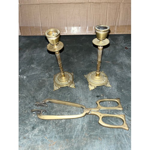 542 - Two brass candlesticks and a pair of coal tongues