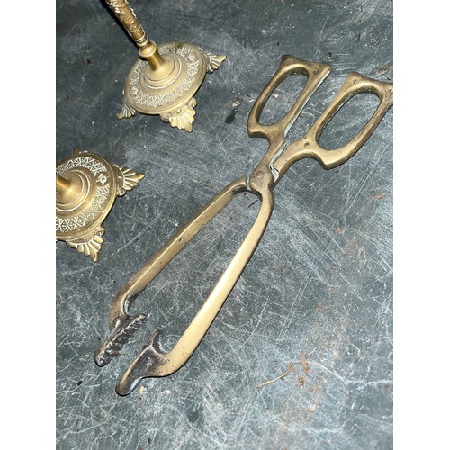 542 - Two brass candlesticks and a pair of coal tongues