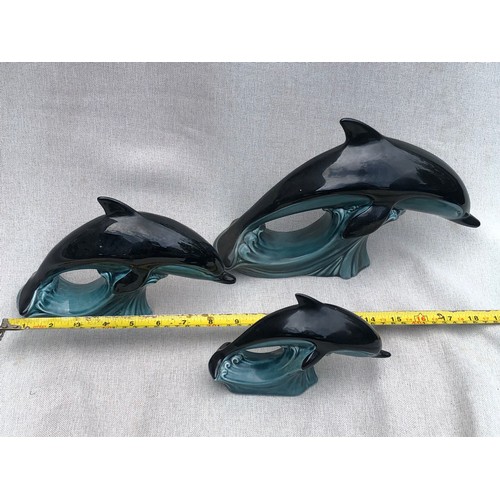 322 - Set of graduating dolphins on waves by Poole pottery