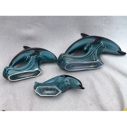 322 - Set of graduating dolphins on waves by Poole pottery