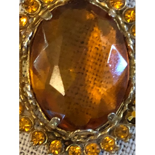 12 - Amber coloured stone set in gold plated setting