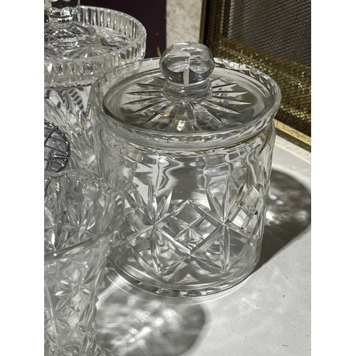 409 - A collection of cut crystal lidded jars a bowl and a green glass fish dish