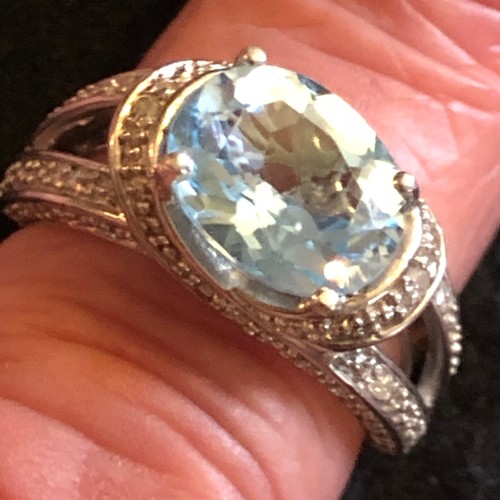 18 - A blue top has four carat gemstone with diamonds white metal ring