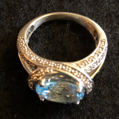 18 - A blue top has four carat gemstone with diamonds white metal ring