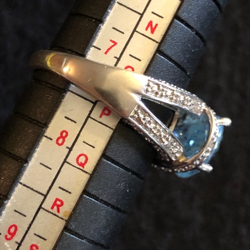 18 - A blue top has four carat gemstone with diamonds white metal ring